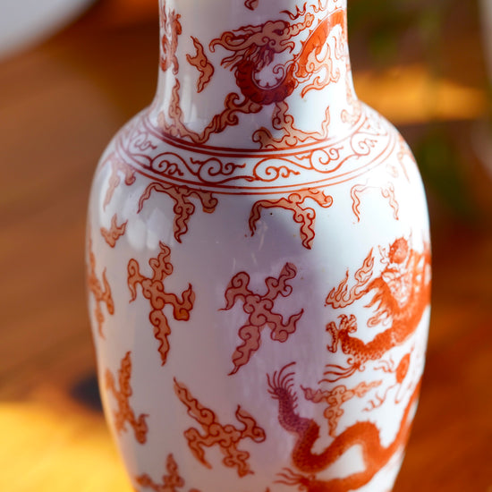 Load image into Gallery viewer, Close up of painted body of vintage orange and white hand painted Japanese porcelain vase with  dragons, displayed on wood floor

